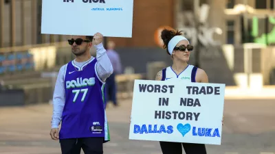 Ryan Safdarinia, left, and Lillian McCall hold signs reacting to the news that the Dallas Mavericks traded Luka Doncic to the Los Angeles Lakers outside the American Airlines Center, Sunday, Feb. 2, 2025, in Dallas. (Elias Valverde II/The Dallas Morning News via AP)