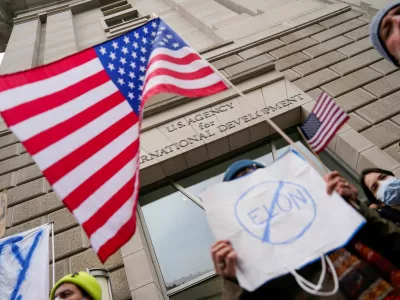 People hold placards outside the USAID building, after billionaire Elon Musk, who is heading U.S. President Donald Trump's drive to shrink the federal government, said work is underway to shut down the U.S. foreign aid agency USAID, in Washington, U.S., February 3, 2025. REUTERS/Kent Nishimura