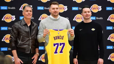 Rob Pelinka (levo) je skupaj s trenerjem J. J. Redickom (desno) poziral na predstavitvi Luke Dončića (v sredini) v novem dresu. Foto: USA TODAY Sports