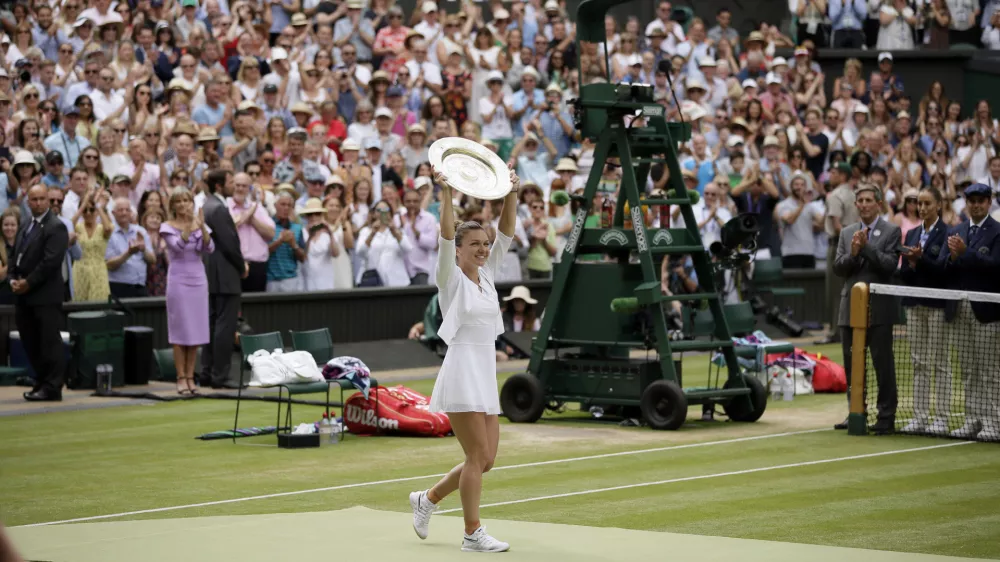 FILE - Romania's Simona Halep holds her trophy after defeating United States' Serena Williams in the women's singles final match on day twelve of the Wimbledon Tennis Championships in London, July 13, 2019. (AP Photo/Tim Ireland, file)
