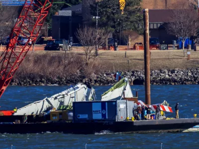 A crane retrieves part of the wreckage from the Potomac River, in the aftermath of the collision of American Eagle flight 5342 and a Black Hawk helicopter that crashed into the river, by the Ronald Reagan Washington National Airport, in Arlington, Virginia, U.S., February 4, 2025. REUTERS/Eduardo Munoz