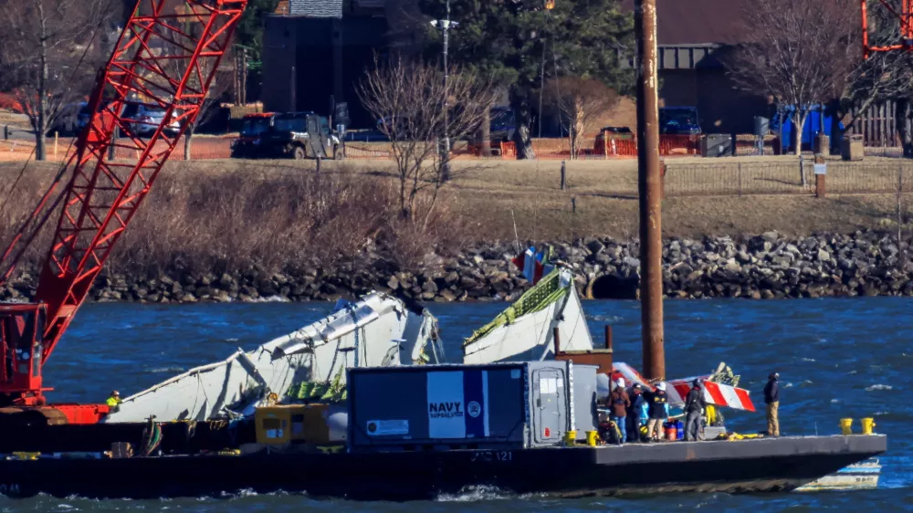 A crane retrieves part of the wreckage from the Potomac River, in the aftermath of the collision of American Eagle flight 5342 and a Black Hawk helicopter that crashed into the river, by the Ronald Reagan Washington National Airport, in Arlington, Virginia, U.S., February 4, 2025. REUTERS/Eduardo Munoz