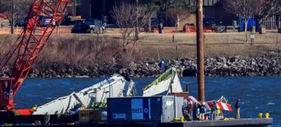 A crane retrieves part of the wreckage from the Potomac River, in the aftermath of the collision of American Eagle flight 5342 and a Black Hawk helicopter that crashed into the river, by the Ronald Reagan Washington National Airport, in Arlington, Virginia, U.S., February 4, 2025. REUTERS/Eduardo Munoz