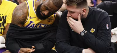 Los Angeles Lakers guard Luka Doncic, right, talks to forward LeBron James on the bench before an NBA basketball game against the Los Angeles Clippers, Tuesday, Feb. 4, 2025, in Inglewood, Calif. (AP Photo/Kevork Djansezian)