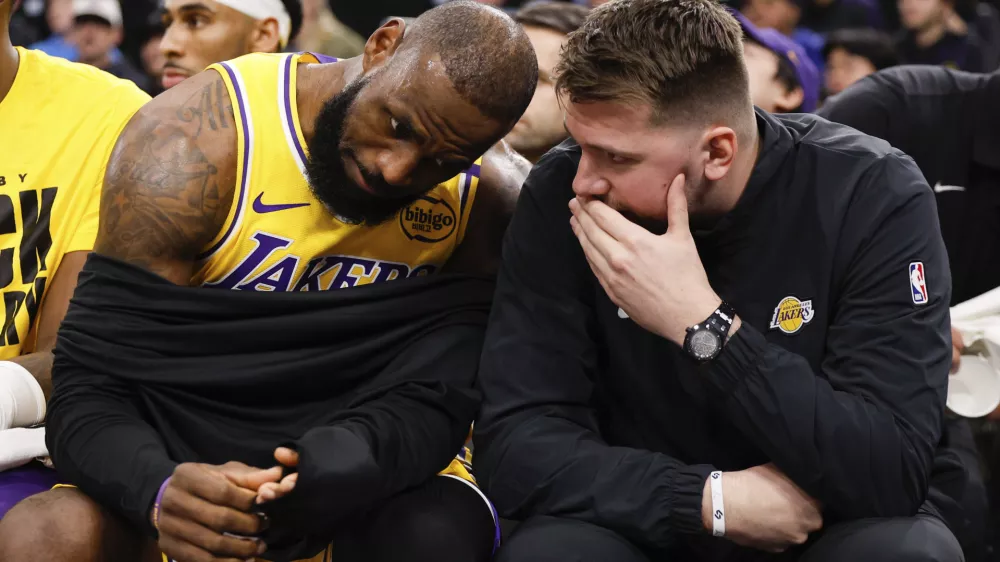 Los Angeles Lakers guard Luka Doncic, right, talks to forward LeBron James on the bench before an NBA basketball game against the Los Angeles Clippers, Tuesday, Feb. 4, 2025, in Inglewood, Calif. (AP Photo/Kevork Djansezian)