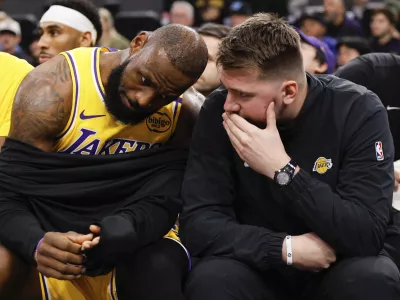 Los Angeles Lakers guard Luka Doncic, right, talks to forward LeBron James on the bench before an NBA basketball game against the Los Angeles Clippers, Tuesday, Feb. 4, 2025, in Inglewood, Calif. (AP Photo/Kevork Djansezian)