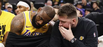 Los Angeles Lakers guard Luka Doncic, right, talks to forward LeBron James on the bench before an NBA basketball game against the Los Angeles Clippers, Tuesday, Feb. 4, 2025, in Inglewood, Calif. (AP Photo/Kevork Djansezian)