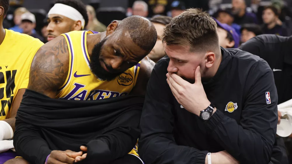 Los Angeles Lakers guard Luka Doncic, right, talks to forward LeBron James on the bench before an NBA basketball game against the Los Angeles Clippers, Tuesday, Feb. 4, 2025, in Inglewood, Calif. (AP Photo/Kevork Djansezian)