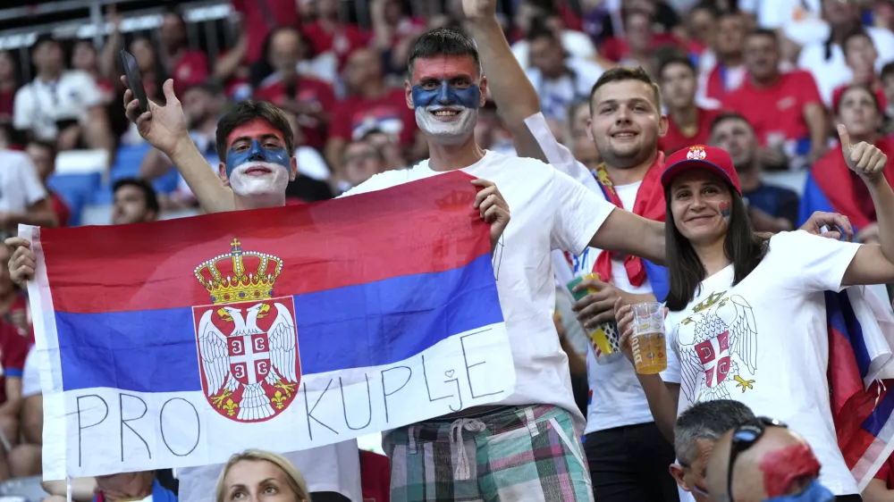 FILE - Fans for Serbia have painted faces and hold a flag in the stands prior to a Group C match between Denmark and Serbia at the Euro 2024 soccer tournament in Munich, Germany, Tuesday, June 25, 2024. (AP Photo/Matthias Schrader, File)