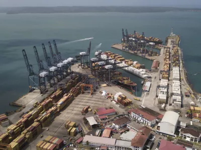 Cargo containers sit stacked as cranes load and unload containers from cargo ships at the Cristobal port, operated by the Panama Ports Company, in Colon, Tuesday, Panama, Feb. 4, 2025. (AP Photo/Matias Delacroix)