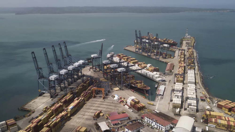 Cargo containers sit stacked as cranes load and unload containers from cargo ships at the Cristobal port, operated by the Panama Ports Company, in Colon, Tuesday, Panama, Feb. 4, 2025. (AP Photo/Matias Delacroix)