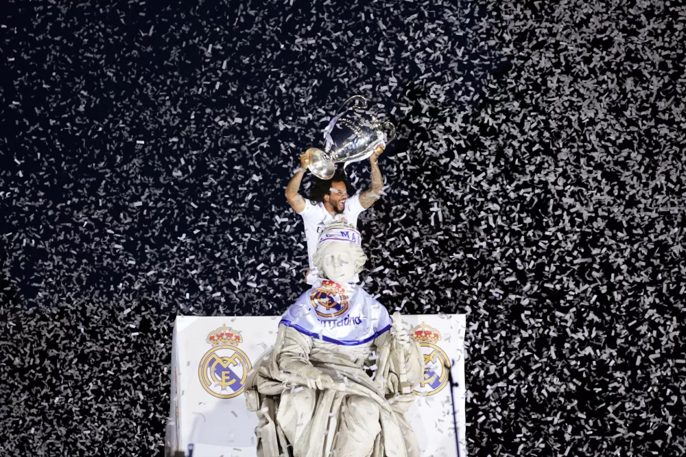 FILE - Real Madrid player Marcelo holds up the Champions League soccer trophy at the Cibeles square during a trophy parade in front of the City Hall in Madrid, Spain, May 29, 2022. (AP Photo/Andrea Comas, File)