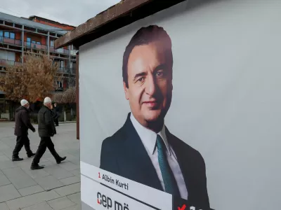 Pedestrians walk near a campaign poster for the upcoming parliamentary elections showing a portrait of Albin Kurti, Kosovo's Prime Minister and leader of the Self-Determination party, in Pristina, Kosovo February 4, 2025. REUTERS/Valdrin Xhemaj