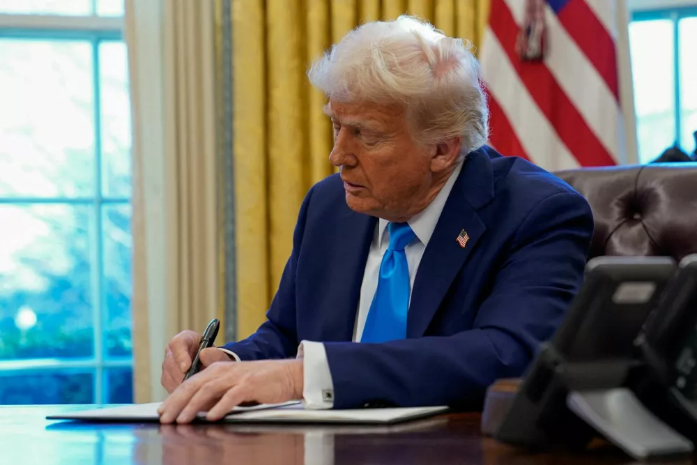 FILE PHOTO: U.S. President Donald Trump signs a document in the Oval Office at the White House in Washington, U.S. February 4, 2025. REUTERS/Elizabeth Frantz/File Photo