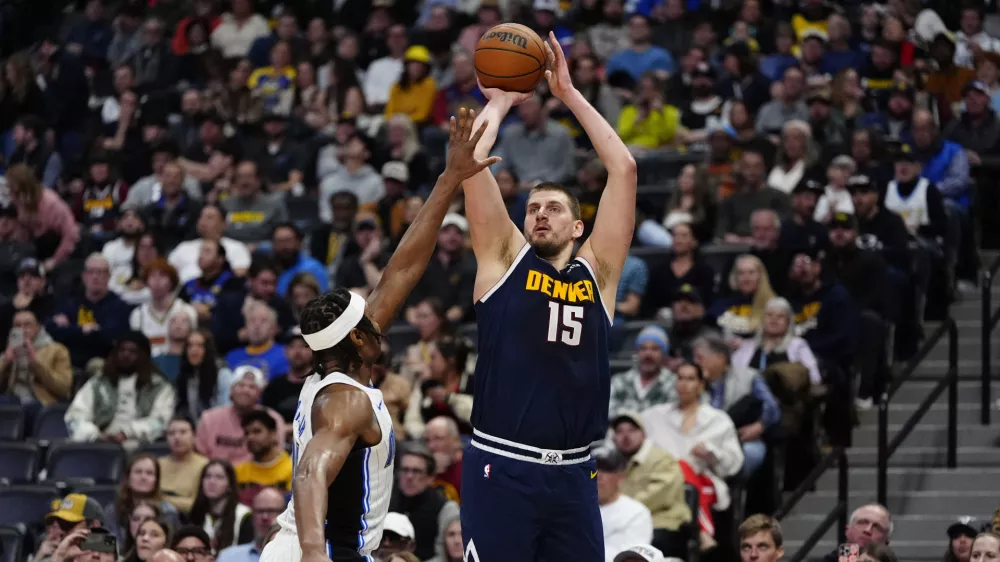 Feb 6, 2025; Denver, Colorado, USA; Denver Nuggets center Nikola Jokic (15) shoots against Orlando Magic forward Paolo Banchero (5) in the second quarter at Ball Arena. Mandatory Credit: Ron Chenoy-Imagn Images