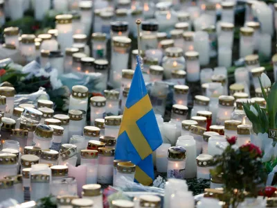 Candles, flowers and a Swedish flag are placed near the Risbergska school, following a deadly shooting attack at the adult education centre, in Orebro, Sweden, February 7, 2025. REUTERS/Kuba Stezycki