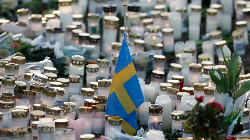 Candles, flowers and a Swedish flag are placed near the Risbergska school, following a deadly shooting attack at the adult education centre, in Orebro, Sweden, February 7, 2025. REUTERS/Kuba Stezycki