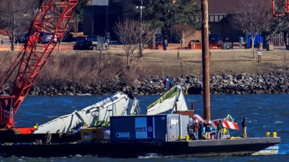 FILE PHOTO: A crane retrieves part of the wreckage from the Potomac River, in the aftermath of the collision of American Eagle flight 5342 and a Black Hawk helicopter that crashed into the river, by the Ronald Reagan Washington National Airport, in Arlington, Virginia, U.S., February 4, 2025. REUTERS/Eduardo Munoz/File Photo