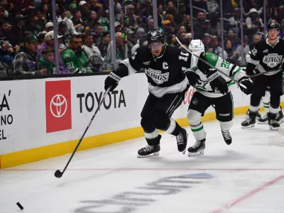 Feb 7, 2025; Los Angeles, California, USA; Los Angeles Kings center Anze Kopitar (11) plays for the puck ahead of Dallas Stars center Mavrik Bourque (22) during the third period at Crypto.com Arena. Mandatory Credit: Gary A. Vasquez-Imagn Images