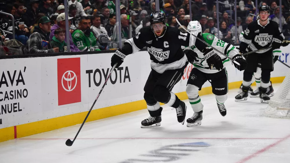 Feb 7, 2025; Los Angeles, California, USA; Los Angeles Kings center Anze Kopitar (11) plays for the puck ahead of Dallas Stars center Mavrik Bourque (22) during the third period at Crypto.com Arena. Mandatory Credit: Gary A. Vasquez-Imagn Images