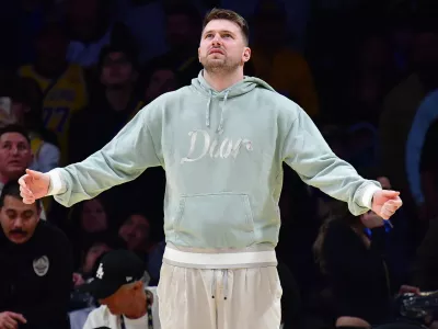 Feb 8, 2025; Los Angeles, California, USA; Los Angeles Lakers guard Luka Doncic (77) reacts watching game action against the Indiana Pacers during the second half at Crypto.com Arena. Mandatory Credit: Gary A. Vasquez-Imagn Images