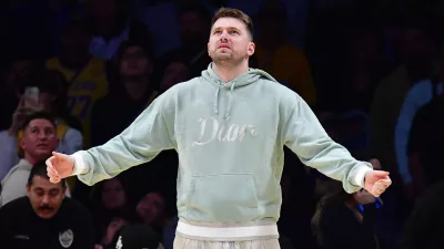 Feb 8, 2025; Los Angeles, California, USA; Los Angeles Lakers guard Luka Doncic (77) reacts watching game action against the Indiana Pacers during the second half at Crypto.com Arena. Mandatory Credit: Gary A. Vasquez-Imagn Images