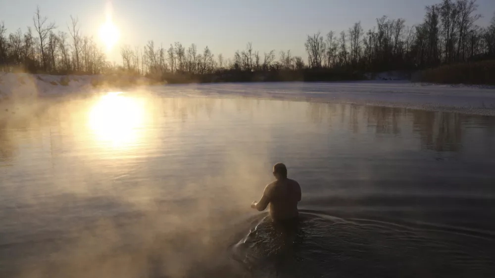 A man bathes in water during a traditional Epiphany celebration as the temperature dropped to about -12 degrees (10,4 degrees Fahrenheit) near the Achairsky monastery outside the Siberian city of Omsk, Russia, early Thursday, Jan. 19, 2023. Across Russia, the devout and the daring are observing the Orthodox Christian feast day of Epiphany by immersing themselves in frigid water through holes cut through the ice of lakes and rivers. Epiphany celebrates the revelation of Jesus Christ as the incarnation of God through his baptism in the River Jordan. (AP Photo/Evgeniy Sofiychuk)