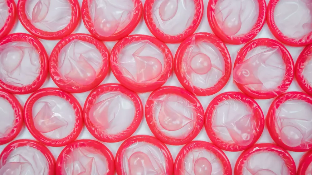 2E1HR89 Top view of pink condoms on white background. Concept of Safe sex. Reduce of pregnancy and sexually transmitted disease. Foto: Reuters/Alamy