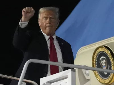 President Donald Trump gestures as he boards Air Force One at the Naval Air Station Joint Reserve Base in New Orleans, Sunday, Feb. 9, 2025. (AP Photo/Ben Curtis)