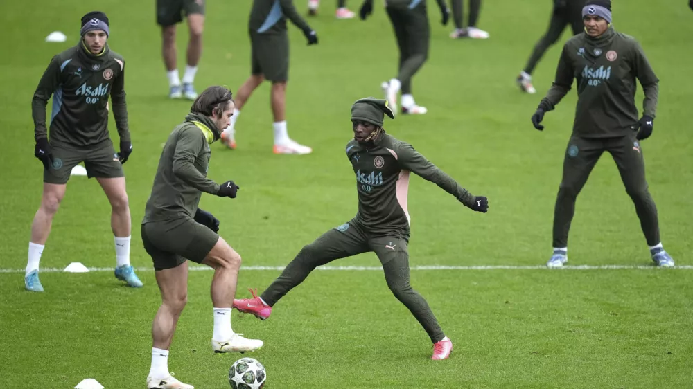 Manchester City's Jack Grealish, front left, and Jeremy Doku, front right, challenge for the ball during a training session in Manchester, England, Monday, Feb. 10, 2025, ahead of the Champions League soccer match between Manchester City and Real Madrid. (Martin Rickett/PA via AP)