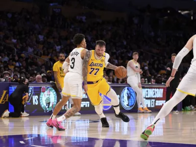 Los Angeles Lakers guard Luka Doncic (77) drives as Utah Jazz guard Keyonte George defends during the second half of an NBA basketball game, Monday, Feb. 10, 2025, in Los Angeles. (AP Photo/Mark J. Terrill)