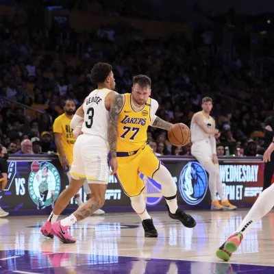 Los Angeles Lakers guard Luka Doncic (77) drives as Utah Jazz guard Keyonte George defends during the second half of an NBA basketball game, Monday, Feb. 10, 2025, in Los Angeles. (AP Photo/Mark J. Terrill)