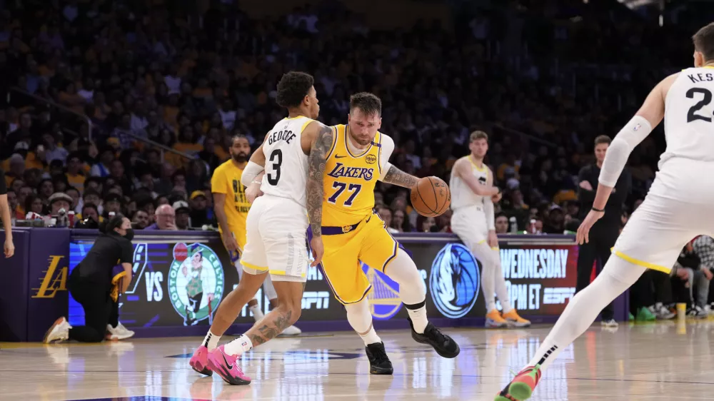 Los Angeles Lakers guard Luka Doncic (77) drives as Utah Jazz guard Keyonte George defends during the second half of an NBA basketball game, Monday, Feb. 10, 2025, in Los Angeles. (AP Photo/Mark J. Terrill)