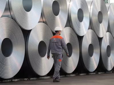 FILED - 12 July 2020, Lower Saxony, Salzgitter: An employee walks along coiled steel at Salzgitter AG. US President Donald Trump's announcement that he is planning to impose 25% tariffs on steel and aluminium imports is hitting the EU steel sector at the worst possible time, a German industry association said on Monday. Photo: Julian Stratenschulte/dpa