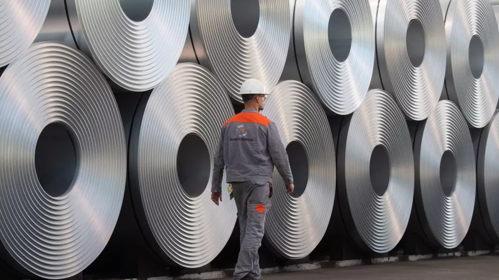 FILED - 12 July 2020, Lower Saxony, Salzgitter: An employee walks along coiled steel at Salzgitter AG. US President Donald Trump's announcement that he is planning to impose 25% tariffs on steel and aluminium imports is hitting the EU steel sector at the worst possible time, a German industry association said on Monday. Photo: Julian Stratenschulte/dpa