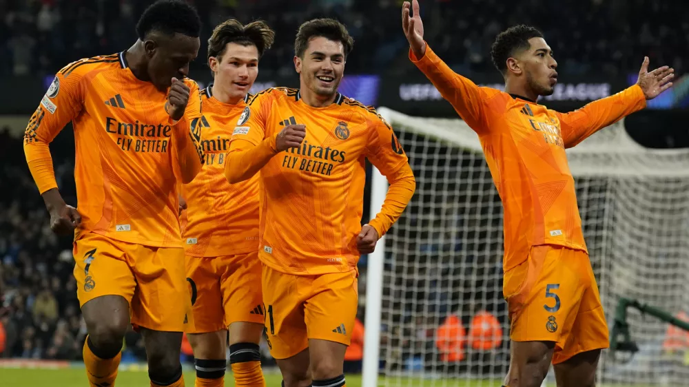 Real Madrid's Jude Bellingham, right, celebrates with teammates after scoring his sides third goal during the Champions League playoff first leg soccer match between Manchester City and Real Madrid at the Etihad Stadium in Manchester, England, Tuesday, Feb. 11, 2025. (AP Photo/Dave Thompson)