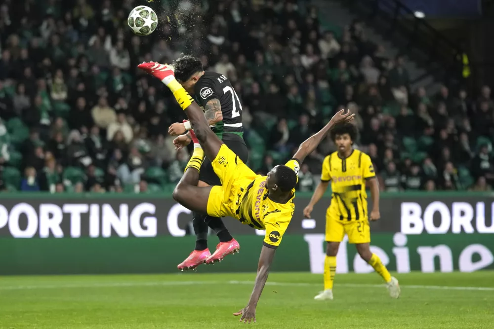 Dortmund's Serhou Guirassy challenges for the ball with Sporting's Maximiliano Araujo during the Champions League playoff first leg soccer match between Sporting CP and Borussia Dortmund at the Alvalade stadium in Lisbon, Portugal, Tuesday, Feb. 11, 2025. (AP Photo/Armando Franca)