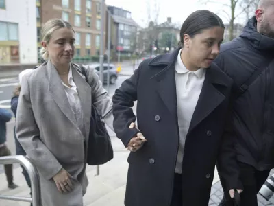 Chelsea and Australia soccer player Sam Kerr, right, arrives wither partner Kristie Mewis at Kingston Crown Court, south west London, Monday, Feb. 10, 2025, where she is charged with alleged racially aggravated harassment of a police officer. (Jonathan Brady/PA via AP)