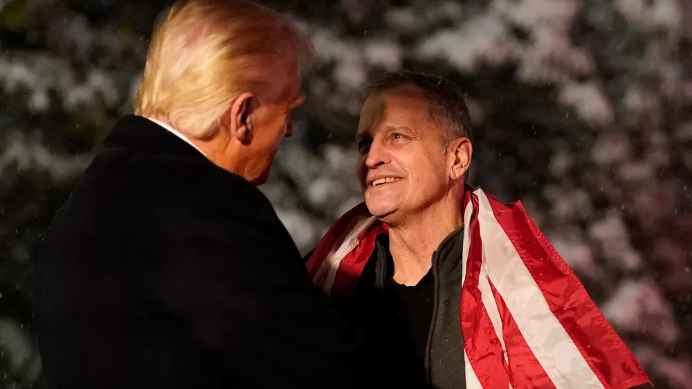 U.S. President Donald Trump greets released American schoolteacher Marc Fogel, who had been held in Russia since 2021, at the White House in Washington, D.C, U.S., February 11, 2025. REUTERS/Nathan Howard