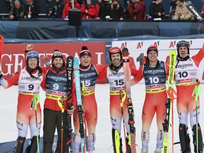 Switzerland's Loic Meillard, third from right, and teammate Franjo von Allmen, third from left, celebrate winning the gold medal in a men's team combined event, with silver medalists Switzerland's Nef Tanguy, left, and teammate Alexis Monney, second from left, and bronze medalists Switzerland's Stefan Rogentin, second from right, and teammate Marc Rochat, at the Alpine Ski World Championships, in Saalbach-Hinterglemm, Austria, Wednesday, Feb. 12, 2025. (AP Photo/Marco Trovati)