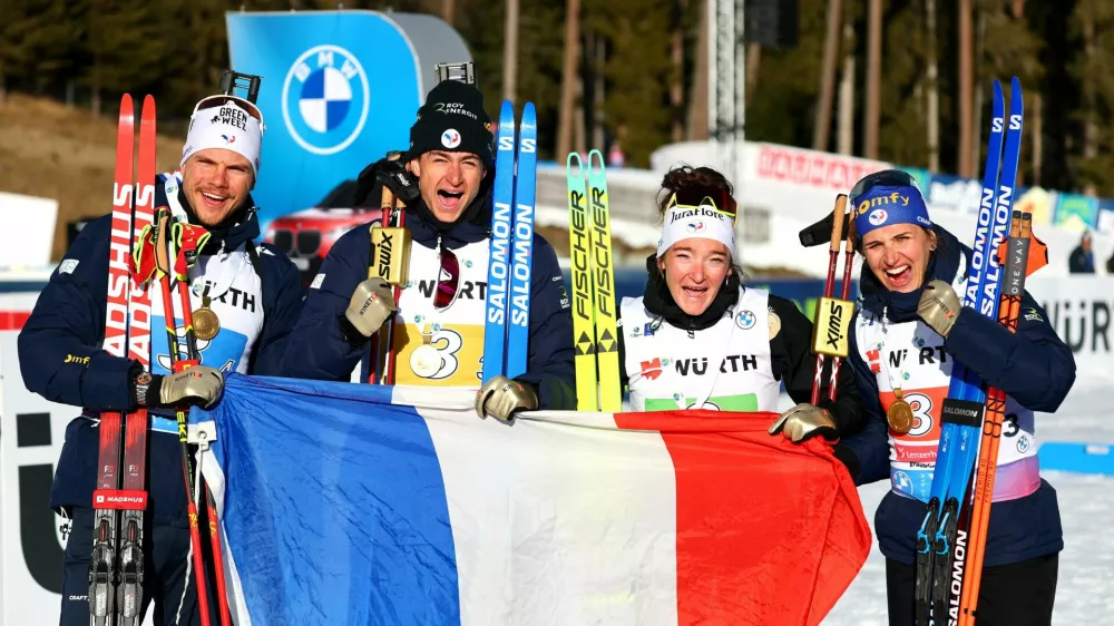 Winter Sports - Biathlon World Championships - 4x6 Mixed Relay - Lenzerheide, Switzerland - February 12, 2025 Gold medallists France's Emilien Jacquelin, Julia Simon, Lou Jeanmonnot and Eric Perrot celebrate with a French flag REUTERS/Denis Balibouse