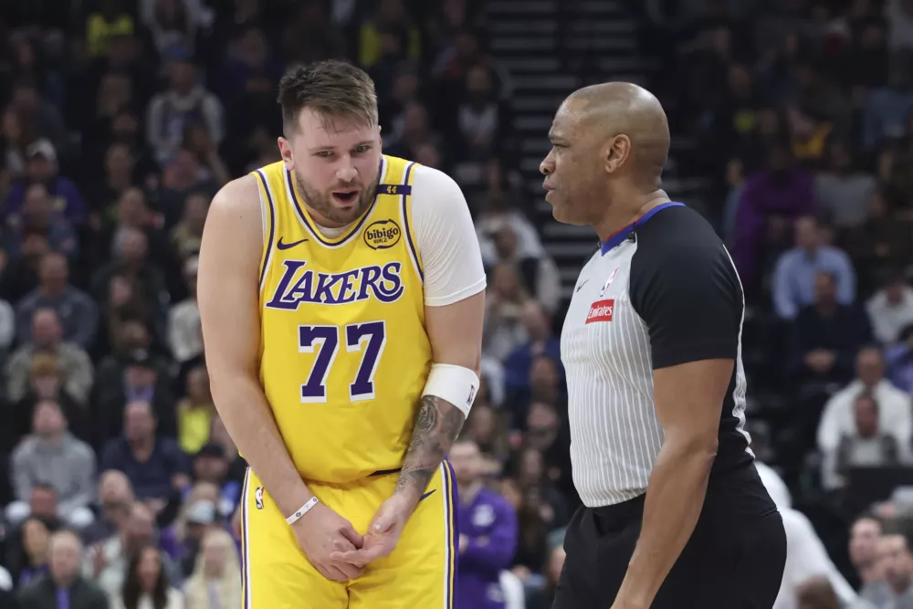 Los Angeles Lakers guard Luka Doncic (77) speaks with referee Tre Maddox (23) about a foul during the second quarter of an NBA basketball game against the Utah Jazz, Wednesday, Feb. 12, 2025, in Salt Lake City. (AP Photo/Rob Gray)