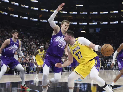 Los Angeles Lakers guard Luka Doncic (77) drives against Utah Jazz forward Lauri Markkanen (23) during the second quarter of an NBA basketball game, Wednesday, Feb. 12, 2025, in Salt Lake City. (AP Photo/Rob Gray)