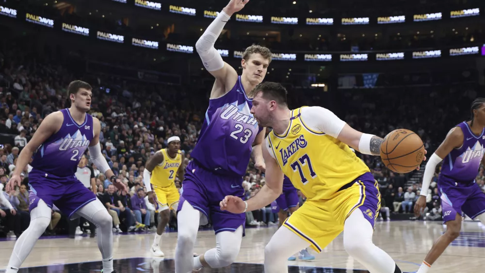 Los Angeles Lakers guard Luka Doncic (77) drives against Utah Jazz forward Lauri Markkanen (23) during the second quarter of an NBA basketball game, Wednesday, Feb. 12, 2025, in Salt Lake City. (AP Photo/Rob Gray)