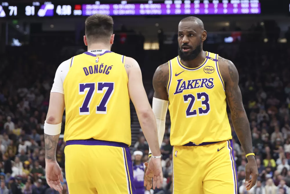 Los Angeles Lakers forward LeBron James (23) slaps hands with guard Luka Doncic (77) during the second half of an NBA basketball game against the Utah Jazz, Wednesday, Feb. 12, 2025, in Salt Lake City. (AP Photo/Rob Gray)