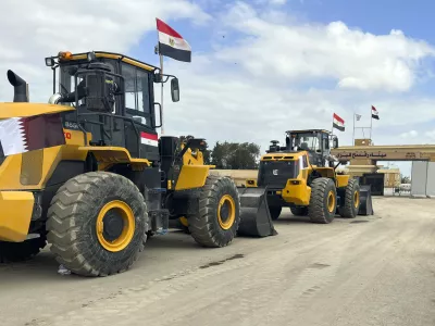 Bulldozers with Egyptian and Qatar flags wait to enter Gaza at the Rafah border crossing between Egypt and the Gaza Strip, Thursday, Feb. 13, 2025. (AP Photo/Mohamed Arafat)