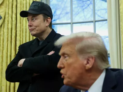 FILE PHOTO: Elon Musk listens to U.S. President Donald Trump speak in the Oval Office of the White House in Washington, D.C., U.S., February 11, 2025.  REUTERS/Kevin Lamarque/File Photo