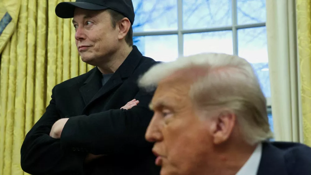 FILE PHOTO: Elon Musk listens to U.S. President Donald Trump speak in the Oval Office of the White House in Washington, D.C., U.S., February 11, 2025.  REUTERS/Kevin Lamarque/File Photo