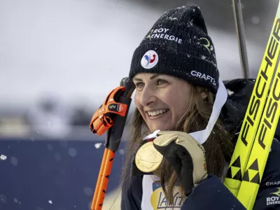 Justine Braisaz-Bouchet of France celebrates on podium winning the women's sprint race of the IBU Biathlon World Championships, Friday, Feb. 14, 2025, in Lenzerheide, Switzerland. (Gian Ehrenzeller/Keystone via AP)