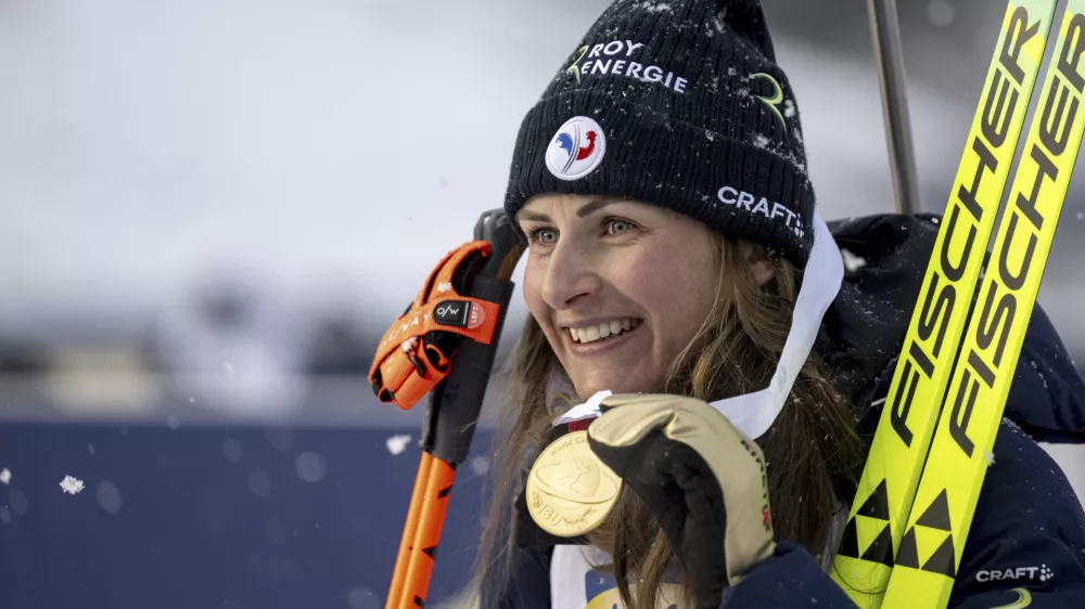 Justine Braisaz-Bouchet of France celebrates on podium winning the women's sprint race of the IBU Biathlon World Championships, Friday, Feb. 14, 2025, in Lenzerheide, Switzerland. (Gian Ehrenzeller/Keystone via AP)